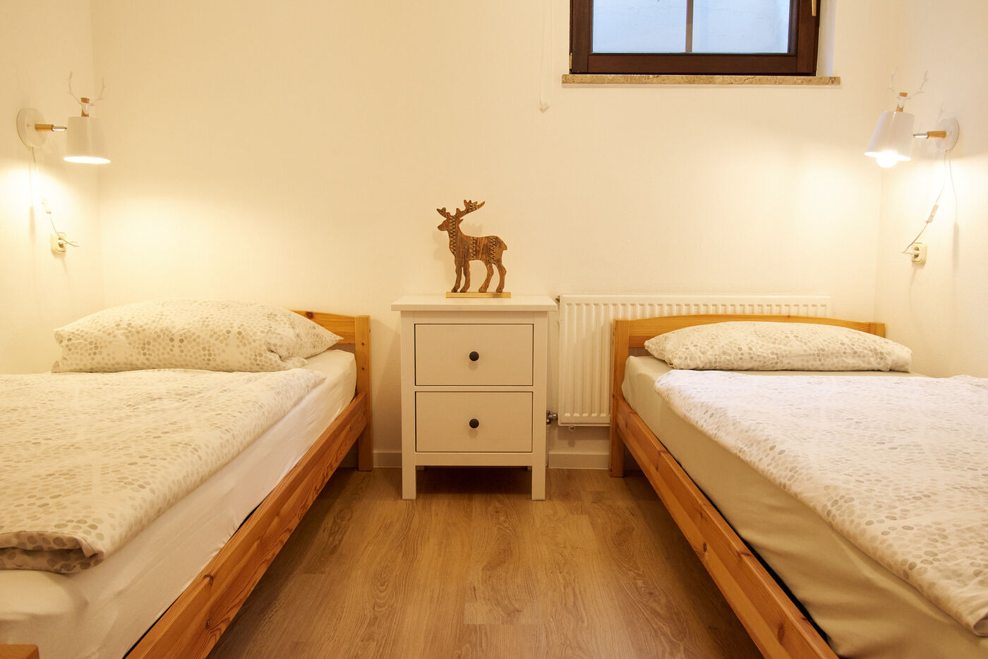 Zweibettzimmer mit hellem Holzboden