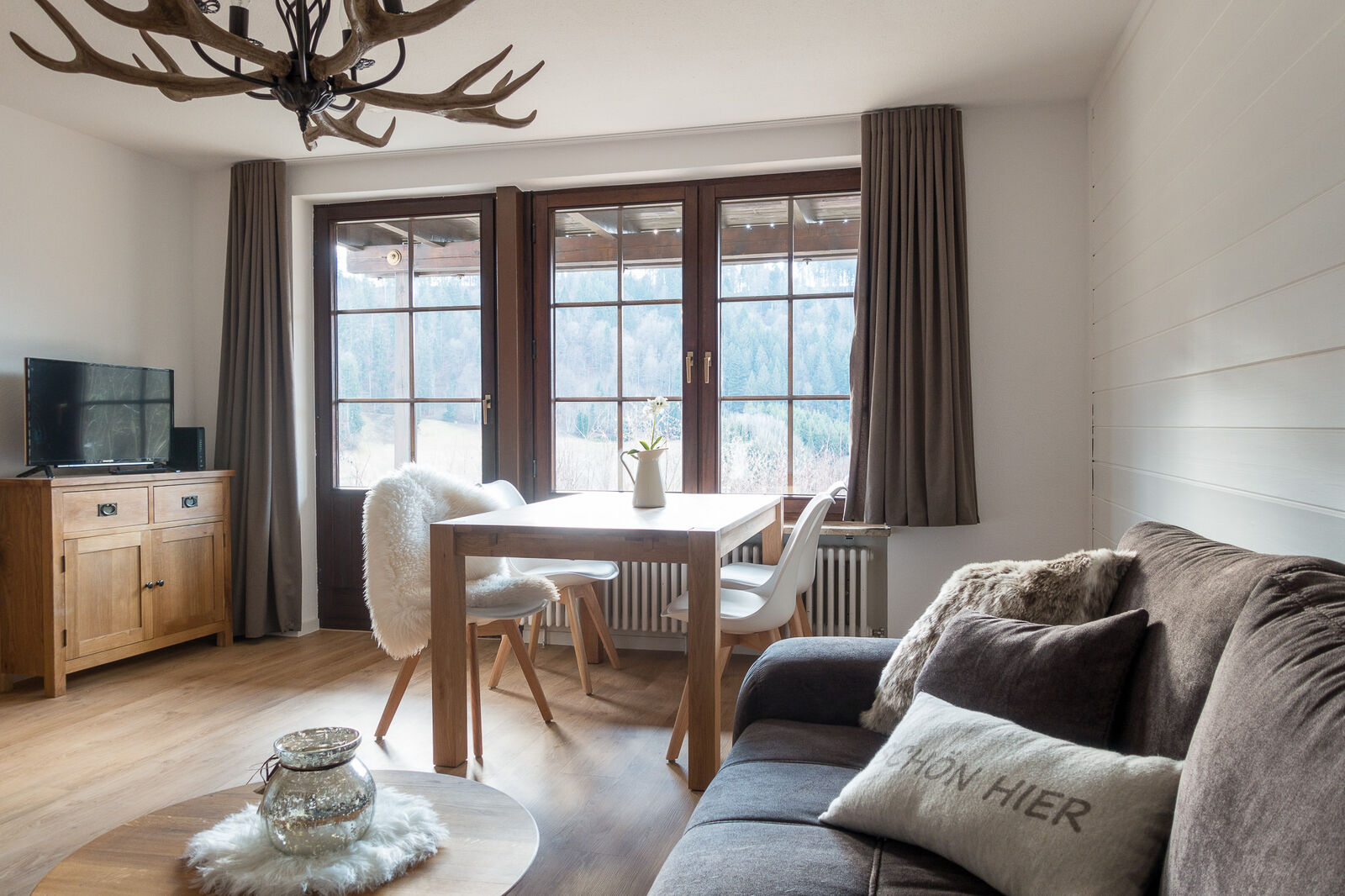 Heller Wohnbereich der Ferienwohnung mit Blick ins Grüne